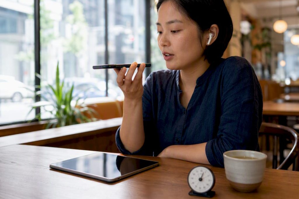 Learner practicing HSKK speaking test with smartphone and timer