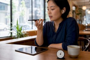 Learner practicing HSKK speaking test with smartphone and timer